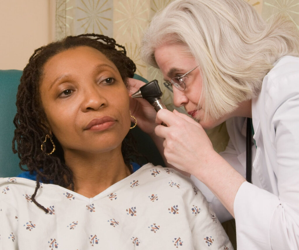 Woman having her ear examined by a health professional